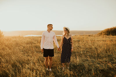 Smiling couple standing on grassy field