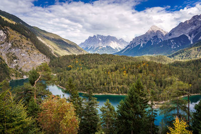 Scenic view of mountains and lake against cloudy sky