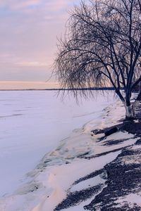 Scenic view of frozen lake against sky during sunset