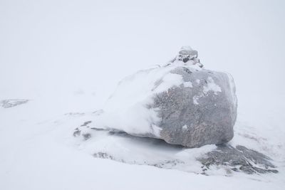 Snow covered land on field against sky