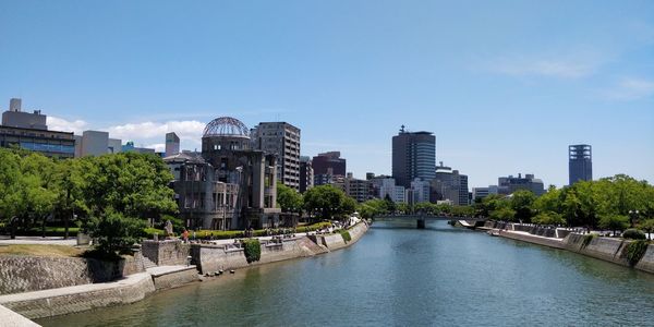 River amidst buildings in city against clear sky