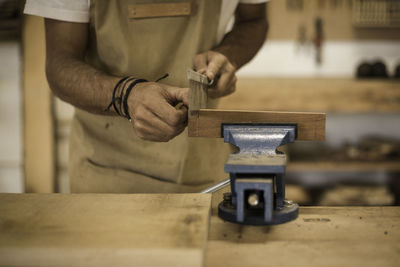 Midsection of carpenter working at workshop