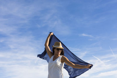 Low angle view of woman standing against sky