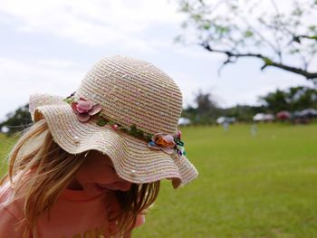 Close-up of hat on field against sky