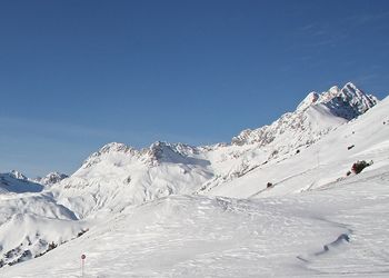 Scenic view of snowcapped mountains against cloudy sky