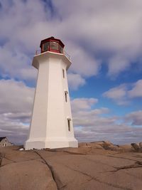 Lighthouse against sky with clouds