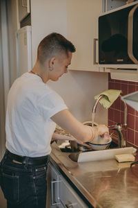 Woman in kitchen washing dishes