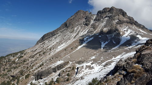 Low angle view of rocky mountains against sky