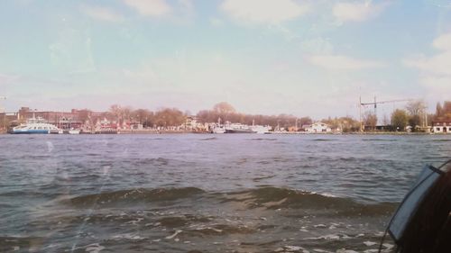 View of boats in river with buildings in background