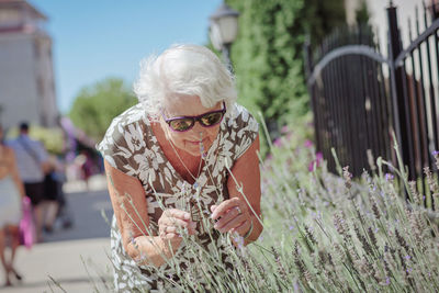 Portrait of an elderly female gardener caring for lavender flowers