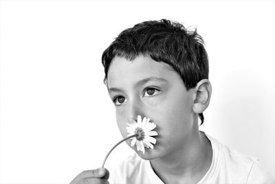 Close-up portrait of man holding red flower against white background