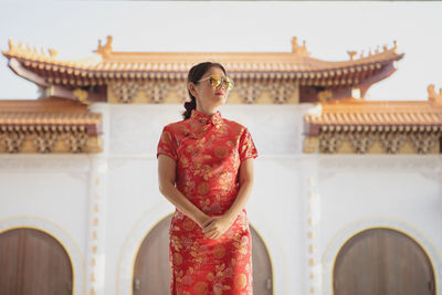 Low angle view of woman looking away while standing against temple