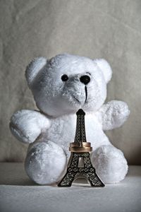 Teddy bear with replica eiffel tower against wall