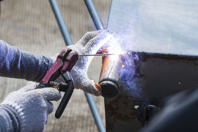 Close-up of man working on metal