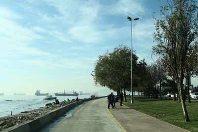 People walking on street against sky