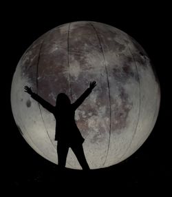 Rear view of silhouette man standing against moon at night