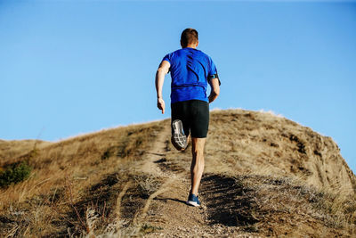 Rear view of man standing on rock