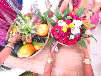 High angle view of people by flowers on table