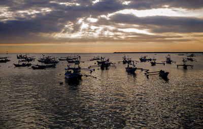 Sailing boats are on the sunset with some fisherman inside after a long working day. 