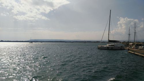 Sailboats in sea against sky