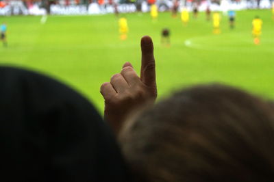 Fan making gesture while watching soccer at stadium