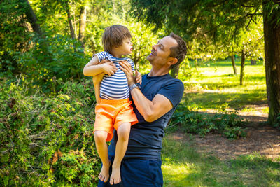 Father and son standing in park