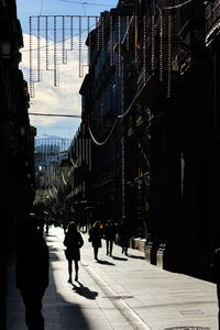 People walking on street amidst buildings in city