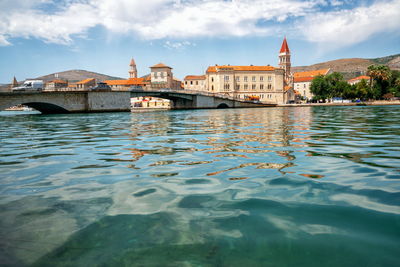 Bridge over river by buildings in city