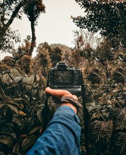 Midsection of man photographing camera on mobile phone