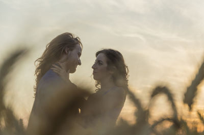 Couple kissing against sky