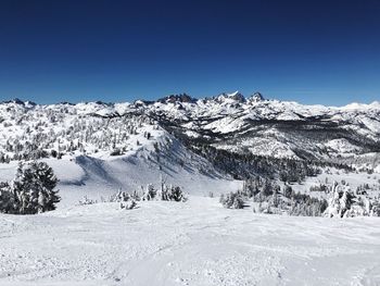 Scenic view of snowcapped mountains against clear blue sky