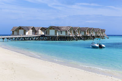 Stilt houses against sky at beach