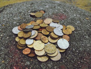 High angle view of coins on rock