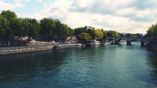 Bridge over river in city against sky