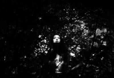 Low angle view of woman standing against trees