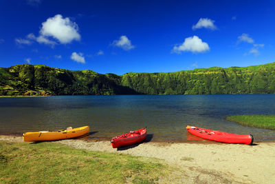 Boats moored on lake against sky