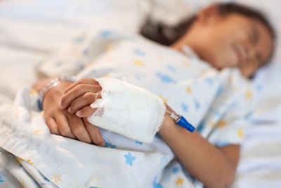 Girl with stomachache lying on bed in hospital