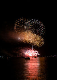 Firework display over river at night