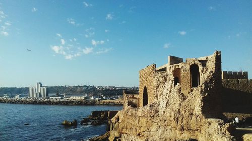 Abandoned built structure by sea against sky 