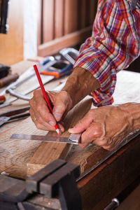 Midsection of carpenter working at workshop