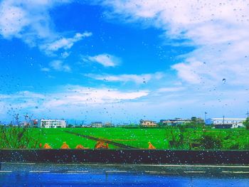 View of field against cloudy sky