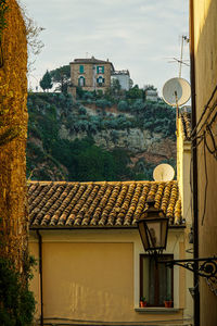 Houses in town against cloudy sky