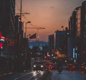 Traffic on city street and buildings at dusk