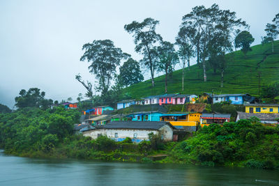 Residential district on mountain by lake against clear sky