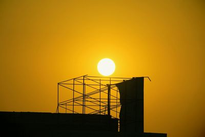 High section of silhouette built structure against sky during sunset