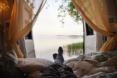Feet of person lying in bed in camper van