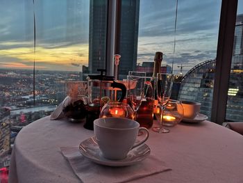 Glass of wine on table against window in city