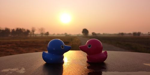 Close-up of toys on table against sky during sunset