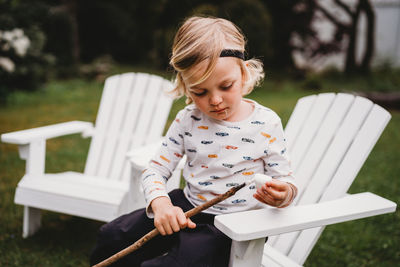 Boy with dirty mouth putting marshmallow on stick to make smores