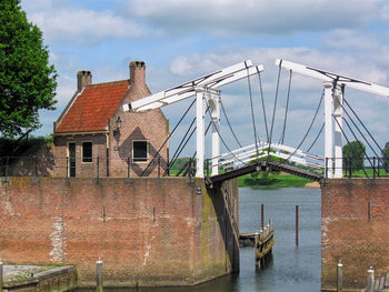 Roof of building by river against sky